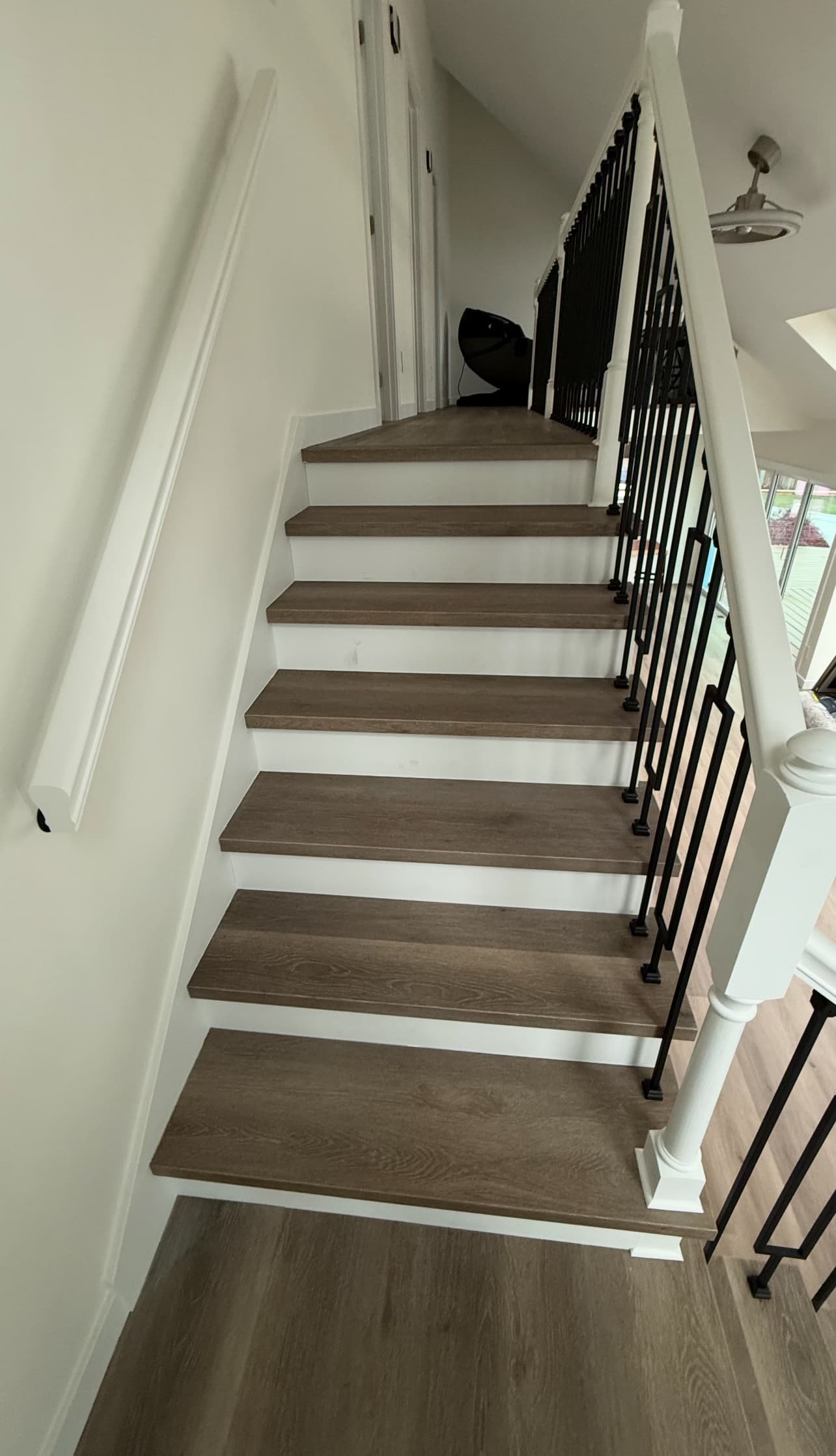 Custom staircase remodel with wood treads and iron balusters